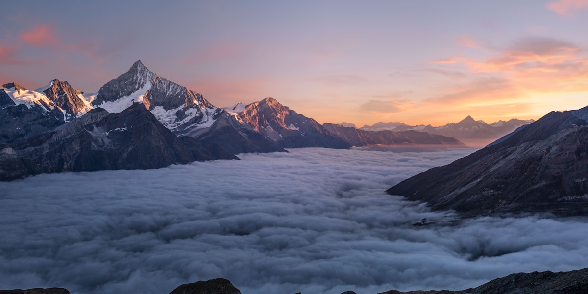 Person reaching a mountain summit, symbolizing overcoming obstacles